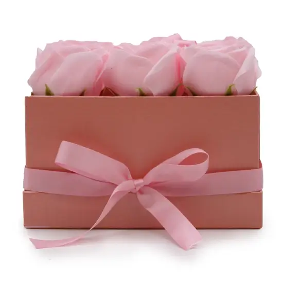 Bouquet de fleurs roses de savon dans un carton rose en forme de carré