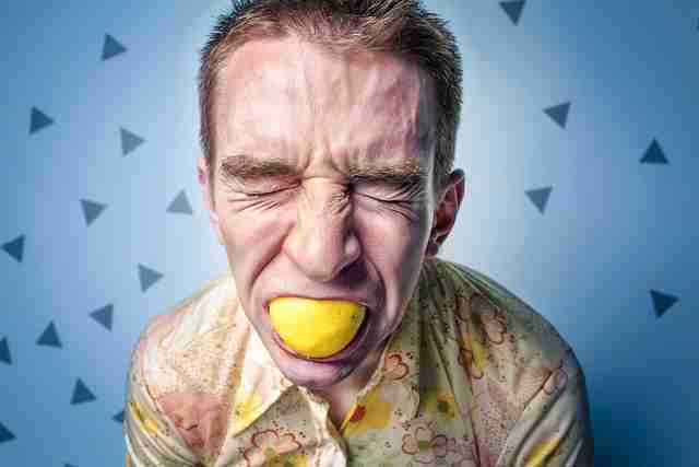 Un homme stressé, avec un citron dans la bouche